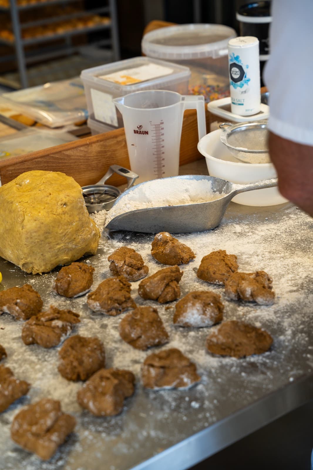 Deeg wordt op een bebloemde tafel in porties verdeeld.